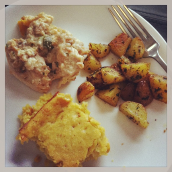 Baked "stuffing" chicken served with creamed corn and baked potatoes